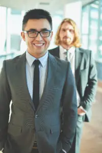 Happy businessman in suit and eyeglasses looking at camera